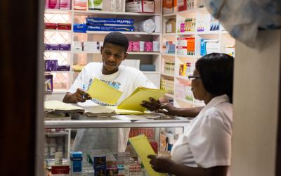 Source - PSI. Pharmacy workers discussing the various commodities available. 